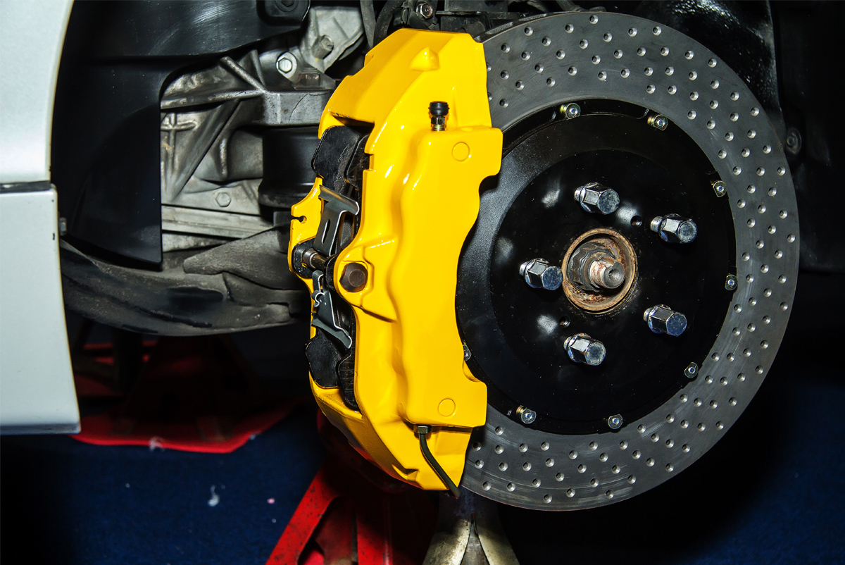 Mechanic replacing worn brake pads during mobile brake repair service