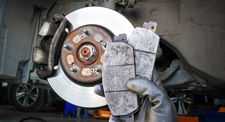 Certified technician performing mobile brake repair and pad replacement on a vehicle